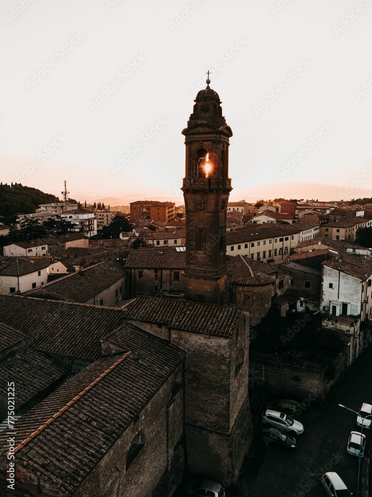 Aerial view of Tuscany cityscape town with an old church, tower and buildings at sunset
