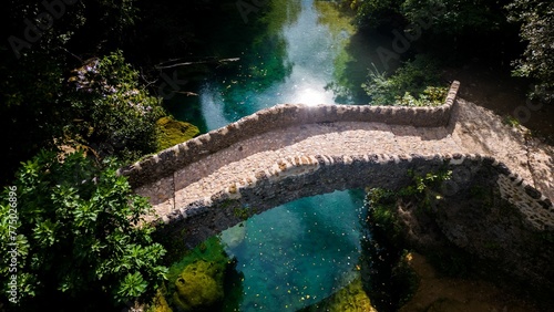 Aerial drone view of a bridge over a clean river on a sunny day