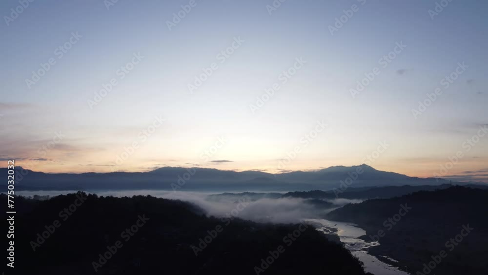 Drone view of a morning sunrise overlooking shadowed lands Drone view of a morning sunrise overlooking shadowed lands