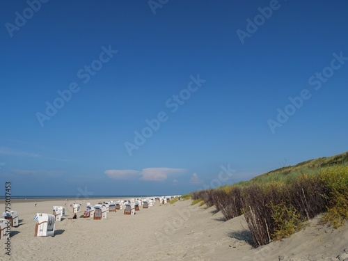 Beach chairs on the sand under blue sky in Spiekeroog town, Germany