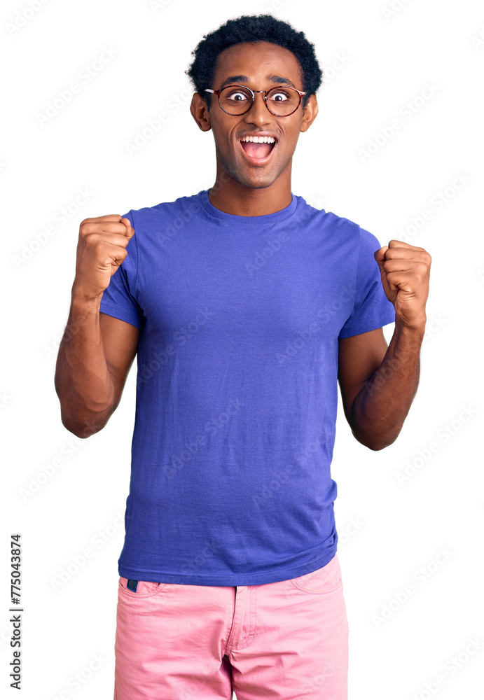 African handsome man wearing casual clothes and glasses celebrating surprised and amazed for success with arms raised and open eyes. winner concept. African handsome man wearing casual clothes and glasses celebrating surprised and amazed for success with arms raised and open eyes. winner concept.