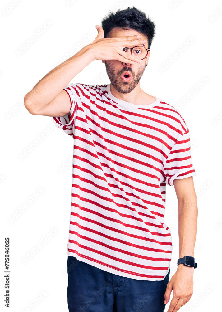 Young hispanic man wearing casual clothes peeking in shock covering face and eyes with hand, looking through fingers with embarrassed expression. Young hispanic man wearing casual clothes peeking in shock covering face and eyes with hand, looking through fingers with embarrassed expression.