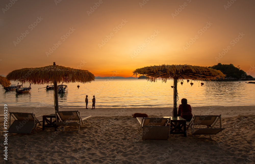 Fototapeta premium Tourist silhouette Enjoy the morning atmosphere on sunrise Beachat Koh Lipe island, Satun Province, South, Thailand.