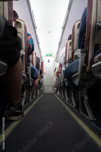 Photography A crowded airplane with people sitting in the aisle