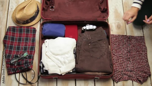 Faceless hands packing luggage for travel. Top view of unrecognizable woman putting clothes into suitcase getting ready. Tourism and lifestyle concept. End of quarantine. Wunderlust for adventure photo