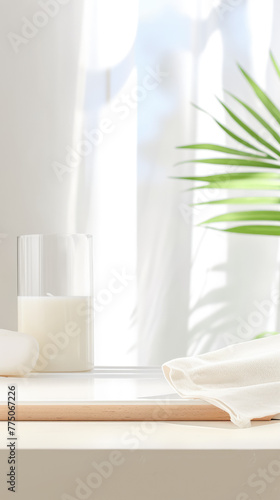 background consisting of a green fern leaf  a white board on the table  a vessel with a white liquid  against the backdrop of an open window and blue sky. Delicate tones