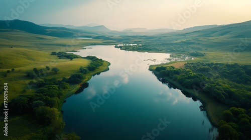 An aerial view of a serene lake nestled among rolling hills and valleys