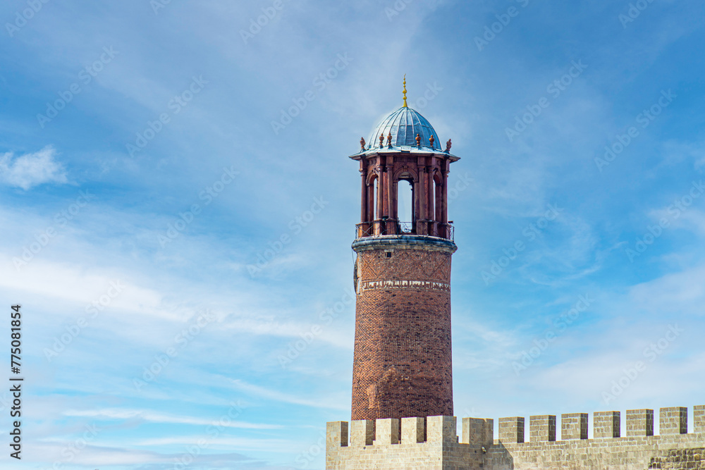 Erzurum Kalesi Saat Kulesi or Erzurum Castle clock tower stands against a serene blue sky.