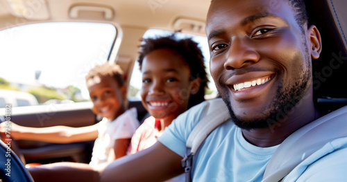 A happy African American family is enjoying a ride in their car.
