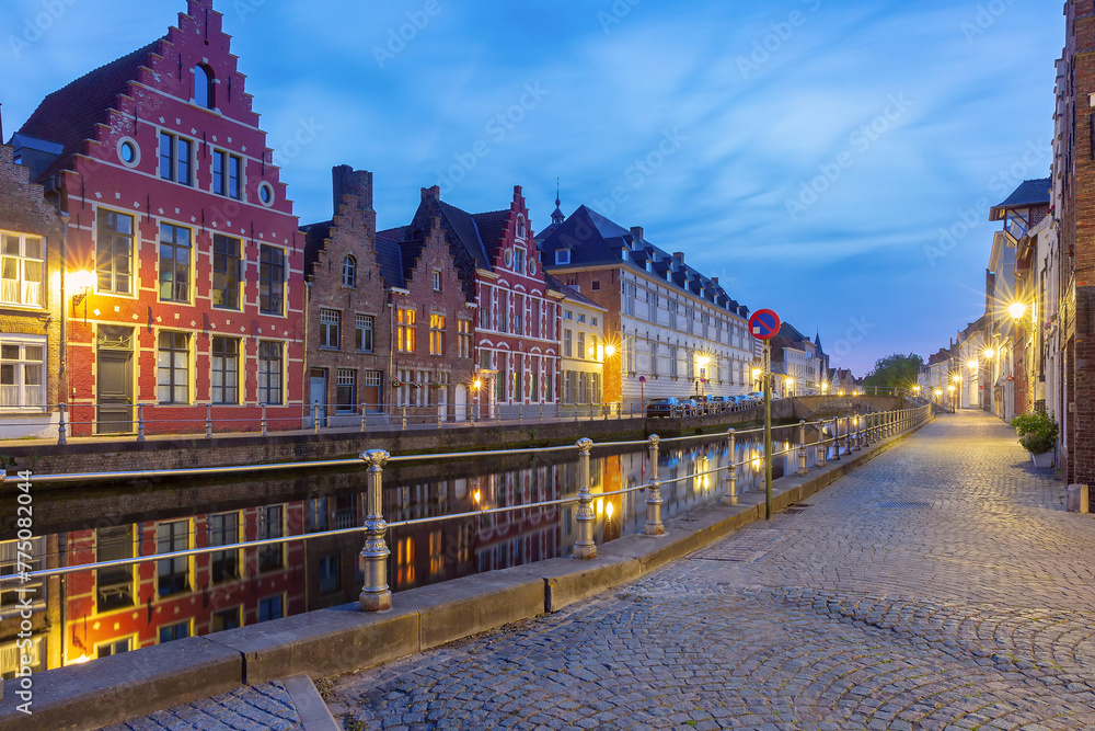 Scenic city view of Bruges canal with beautiful medieval Dutch houses during blue hour, Belgium