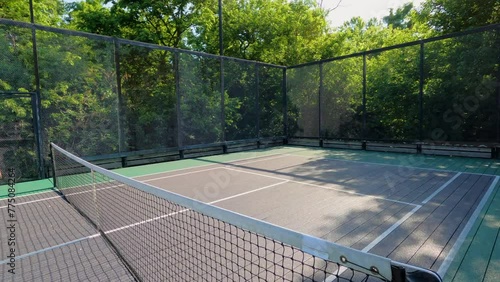 Pickleball or Paddle Tennis Courts. Elevated sport courts with nets in a public park setting. Courts are used for paddle tennis or pickleball play. Floor is green and blue with white boundary lines.
