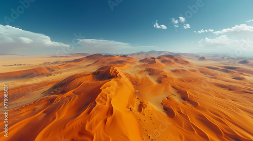 An aerial view of a vast desert landscape with winding sand dunes stretching into the distance © Be Naturally