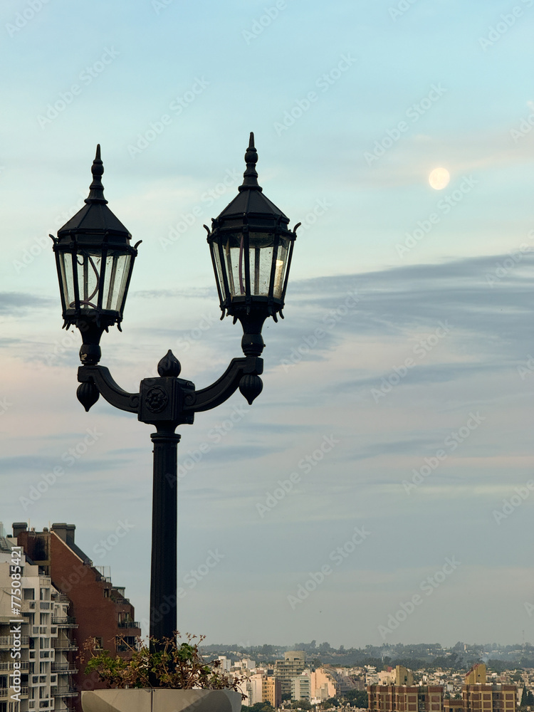A street light with a moon in the sky A street light with a moon in the sky
