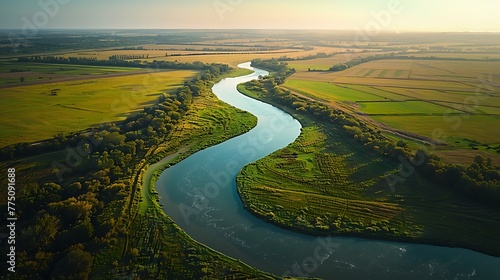 An aerial view of a winding river snaking through a patchwork of agricultural fields