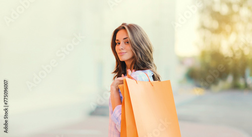 happy brunette young woman with shopping bags walking in the city
