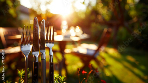 Outdoor Dining Setup With Cutlery in Focus Against a Sunset Background photo