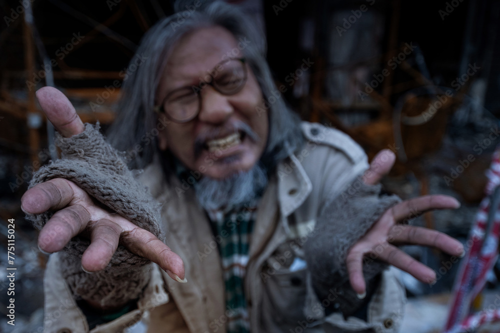 Old man showed signs of madness like a madman. When he saw his house destroyed by fire, homeless old man in front of a building destroyed by fire, selective focus