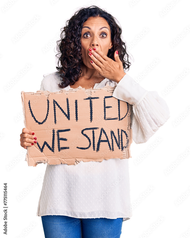 Middle age beautiful woman holding united we stand banner covering mouth with hand, shocked and afraid for mistake. surprised expression Middle age beautiful woman holding united we stand banner covering mouth with hand, shocked and afraid for mistake. surprised expression