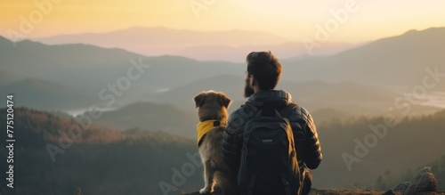 Man with beard and his small yellow dog enjoying mountain sunset and looking at the distance.