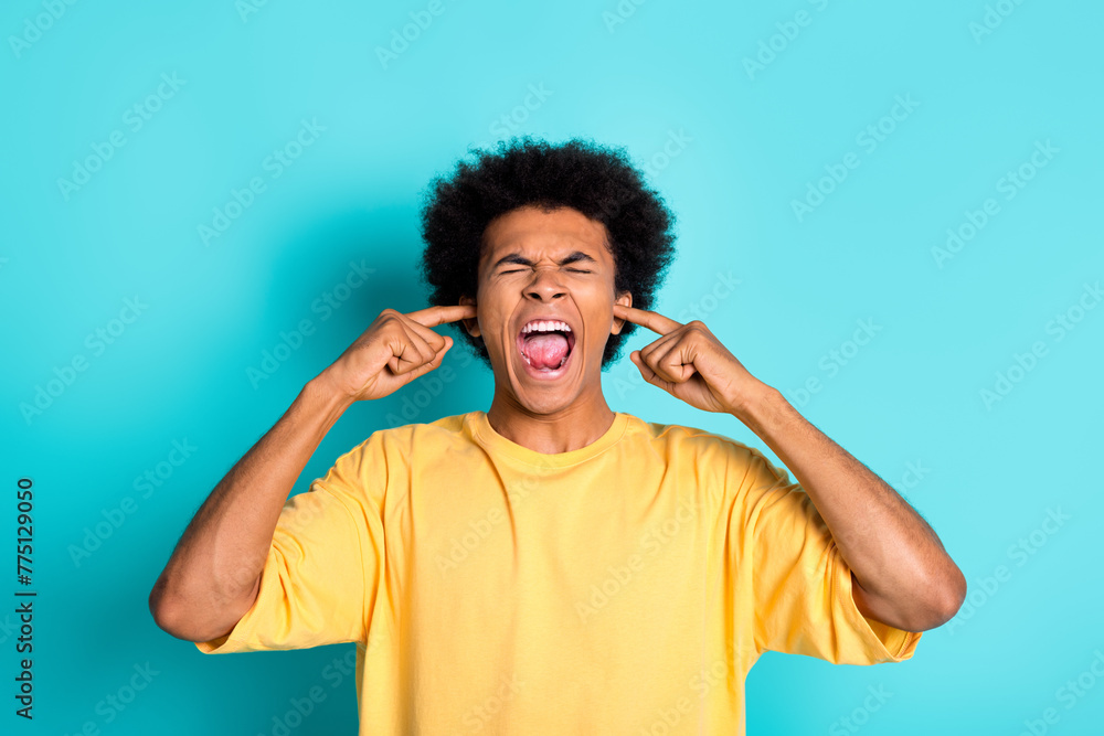 Photo of stressed overwhelmed man with afro hairstyle wear oversize t-shirt shout fingers close ears isolated on teal color background Photo of stressed overwhelmed man with afro hairstyle wear oversize t-shirt shout fingers close ears isolated on teal color background