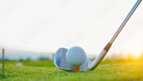 Golf clubs and golf balls on a green lawn in a beautiful golf course with morning sunshine. photo