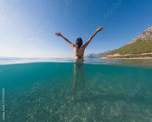 Woman on tropical vacation paradise on sea. Summer sea joy in Turkish seacoast, beaches along Lycian Way, Turkish Riviera. Asian female underwater and turquoise ocean around.