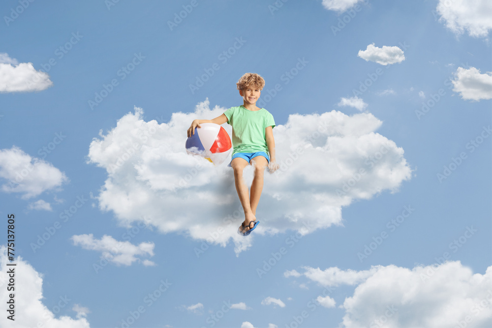 Boy with a beach ball sitting on a cloud