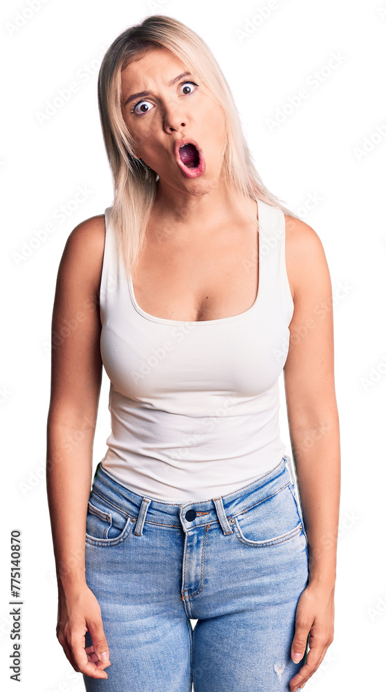 Young beautiful blonde woman wearing casual sleeveless t-shirt afraid and shocked with surprise expression, fear and excited face. Young beautiful blonde woman wearing casual sleeveless t-shirt afraid and shocked with surprise expression, fear and excited face.