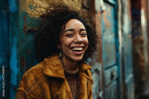 Portrait of a beautiful young african american woman laughing outdoors. © Loli