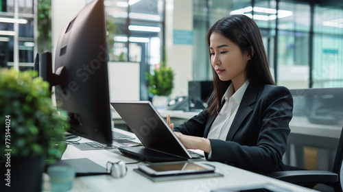 Mulher asiatica usando um tablet no escritório 