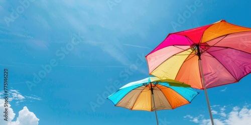two colorful beach umbrellas against the blue sky  summer background