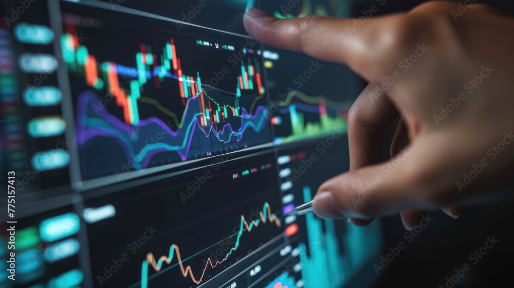 Close-up of a hand pointing at specific data points on a glowing stock market graph on a screen