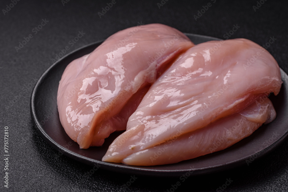 Fresh chicken fillet on a dark concrete table with spices and herbs Fresh chicken fillet on a dark concrete table with spices and herbs
