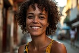 Portrait of young beautiful African woman with curly hair smiling in the city.