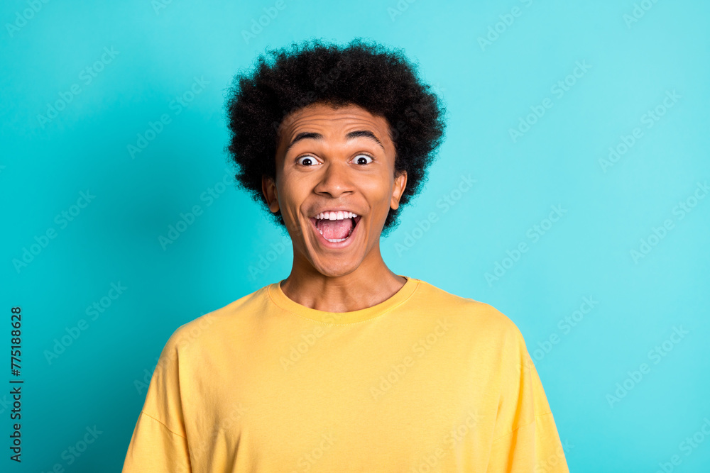 Portrait of overjoyed ecstatic man with afro hairstyle wear oversize t-shirt staring at awesome sale isolated on teal color background Portrait of overjoyed ecstatic man with afro hairstyle wear oversize t-shirt staring at awesome sale isolated on teal color background