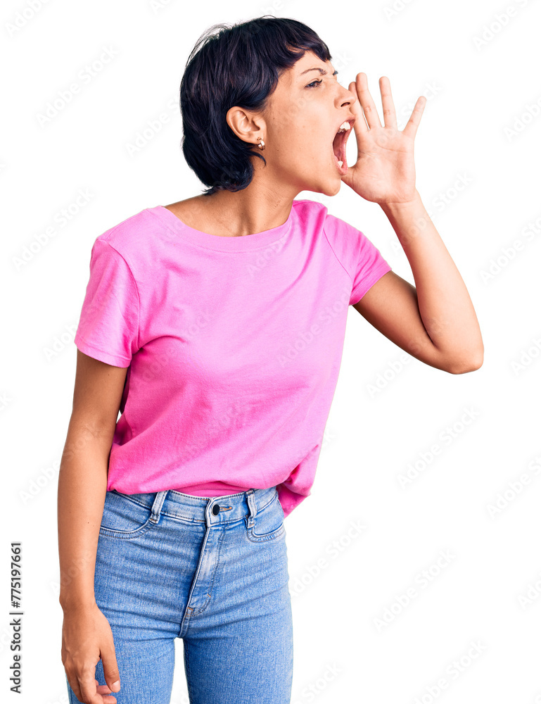 Young brunette woman with short hair wearing casual clothes shouting and screaming loud to side with hand on mouth. communication concept. Young brunette woman with short hair wearing casual clothes shouting and screaming loud to side with hand on mouth. communication concept.