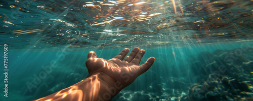 Underwater view with human hand reaching out