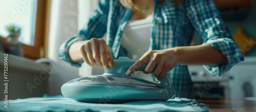Woman ironing clothes on a table in a kitchen photo