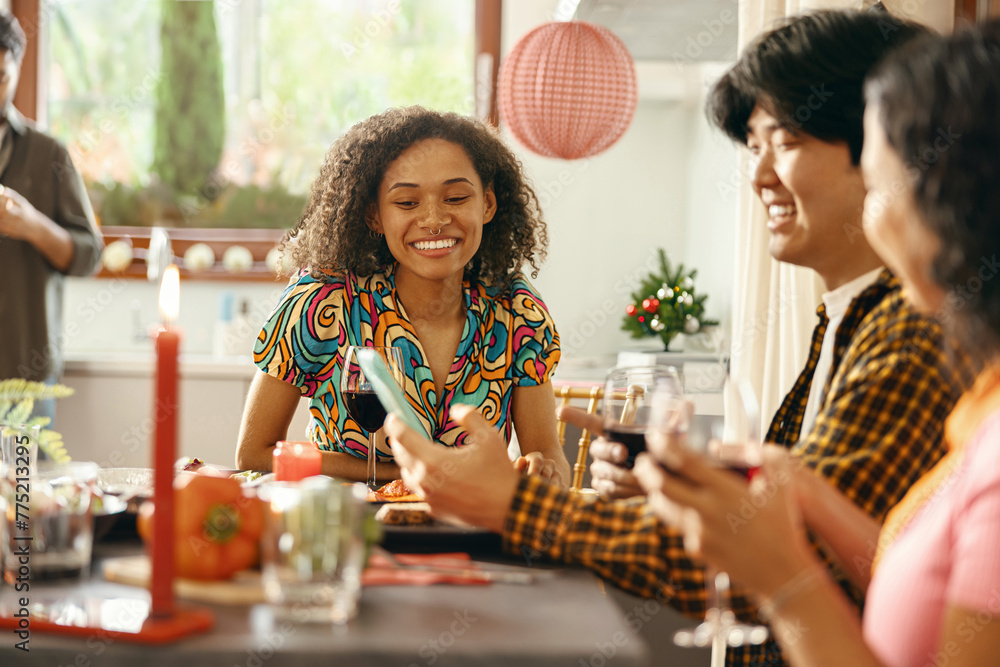 Close up of smiling friends drinking wine and enjoying time together at holiday dinner party at home Close up of smiling friends drinking wine and enjoying time together at holiday dinner party at home