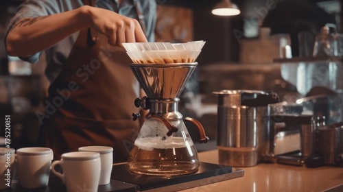 Professional barista making filtered drip coffee in coffee shop. Close up of hands barista brewing a drip hot espresso