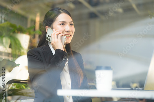 Businesswoman communicating on smartphone in cafe