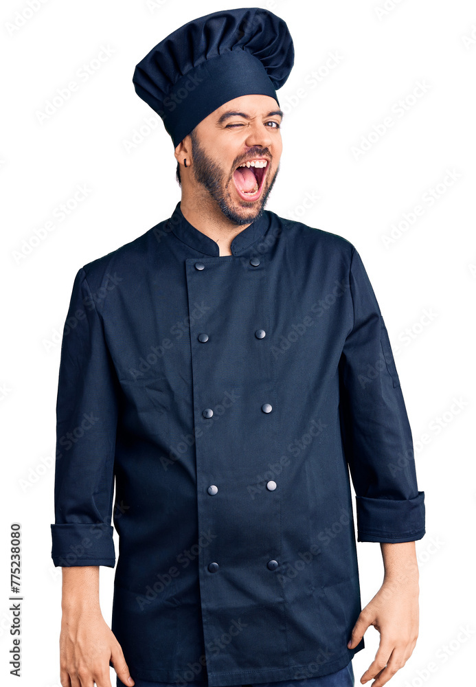 Young hispanic man wearing cooker uniform winking looking at the camera with sexy expression, cheerful and happy face. Young hispanic man wearing cooker uniform winking looking at the camera with sexy expression, cheerful and happy face.