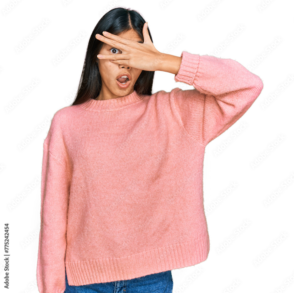 Beautiful young asian woman wearing casual winter sweater peeking in shock covering face and eyes with hand, looking through fingers with embarrassed expression. Beautiful young asian woman wearing casual winter sweater peeking in shock covering face and eyes with hand, looking through fingers with embarrassed expression.