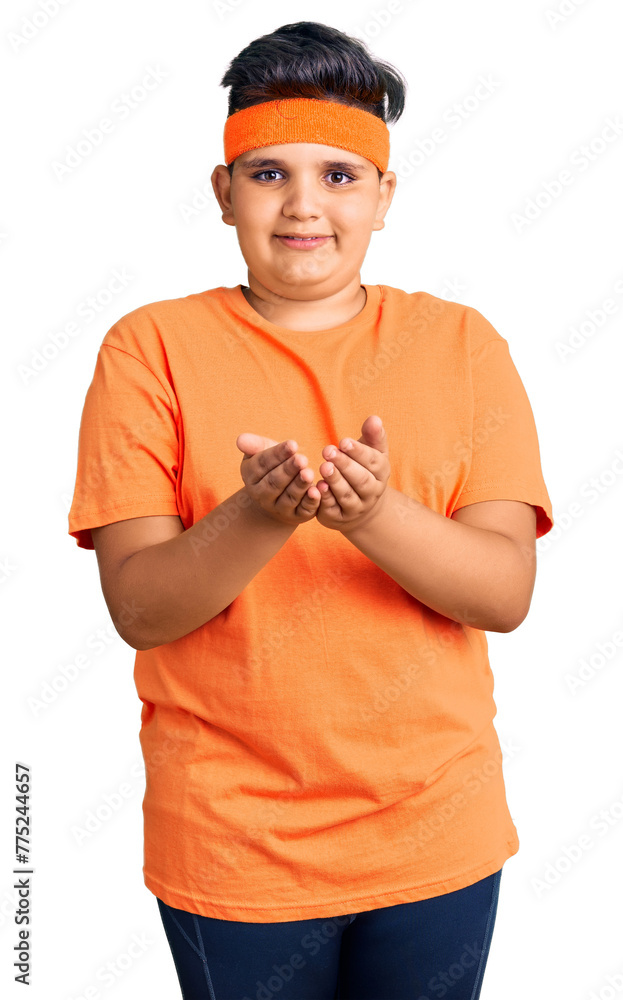 Little boy kid wearing sportswear smiling with hands palms together receiving or giving gesture. hold and protection Little boy kid wearing sportswear smiling with hands palms together receiving or giving gesture. hold and protection