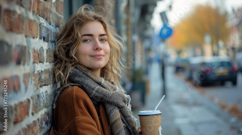 Woman Standing by Brick Wall With Coffee Cup