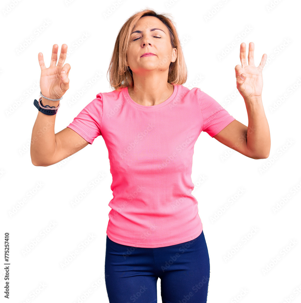 Young blonde woman wearing sportswear relaxed and smiling with eyes closed doing meditation gesture with fingers. yoga concept. Young blonde woman wearing sportswear relaxed and smiling with eyes closed doing meditation gesture with fingers. yoga concept.