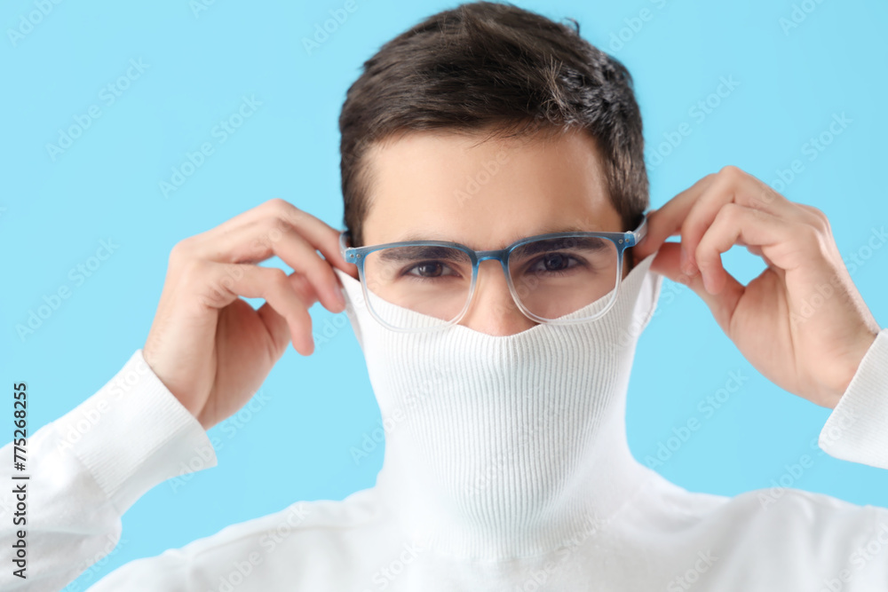 Young man in eyeglasses on blue background, closeup Young man in eyeglasses on blue background, closeup