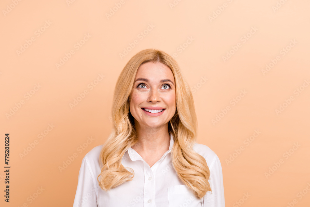 Photo of curly hair blonde young woman in white shirt looking up head thinking bright future plans isolated on beige color background Photo of curly hair blonde young woman in white shirt looking up head thinking bright future plans isolated on beige color background