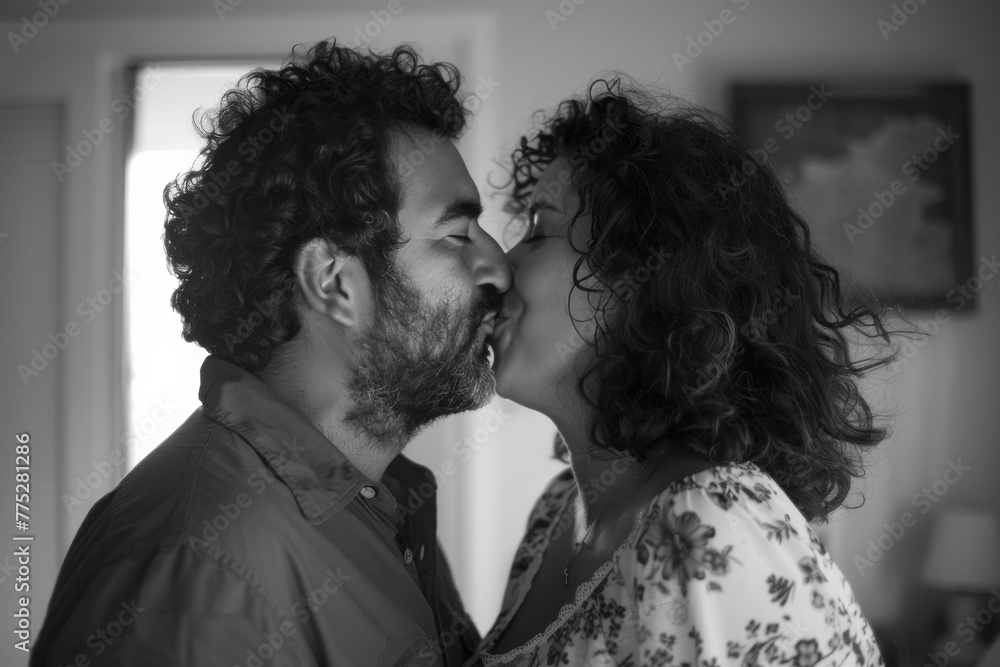 A black and white photo of a man and woman kissing A black and white photo of a man and woman kissing