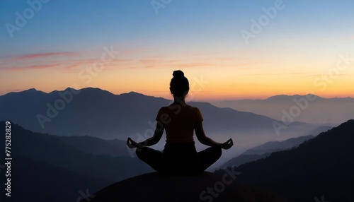  A silhouette of a woman meditating on a mountaintop during sunset. The serene landscape reveals a gradient sky and layers of distant mountains
